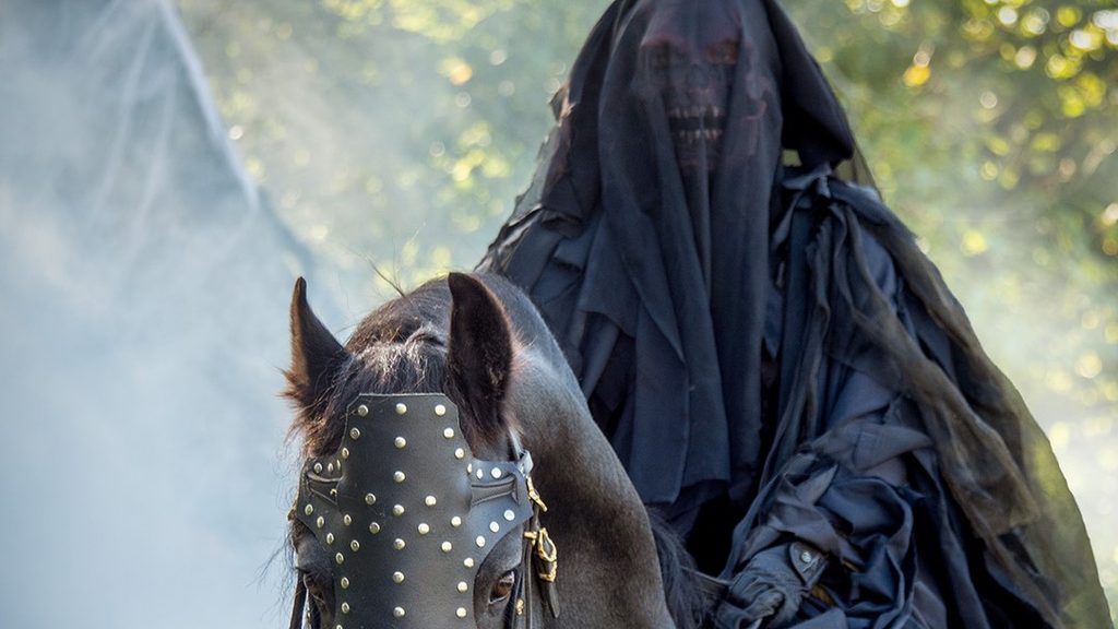 Legendia Parc : cavalier masqué sur un cheval noir dans une ambiance mystérieuse