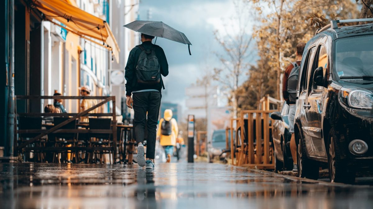 Personne marchant sous la pluie avec un parapluie dans une rue à Nantes